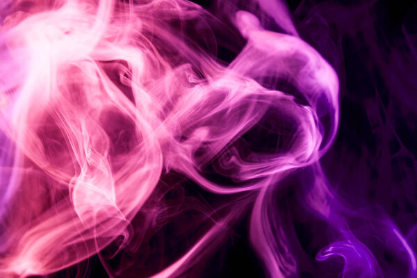 Dense pinkmulticolored smoke on a black isolated background. Background of smoke vape