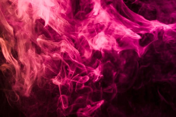 Thick pink and red colorful smoke on a black isolated background. Background from the smoke of vape