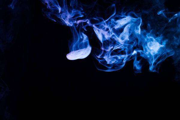 Thick blue colorful smoke on a black isolated background. Background from the smoke of vape