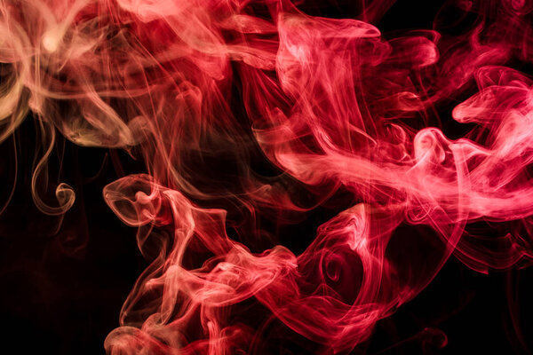 Thick red colorful smoke on a black isolated background. Background from the smoke of vape