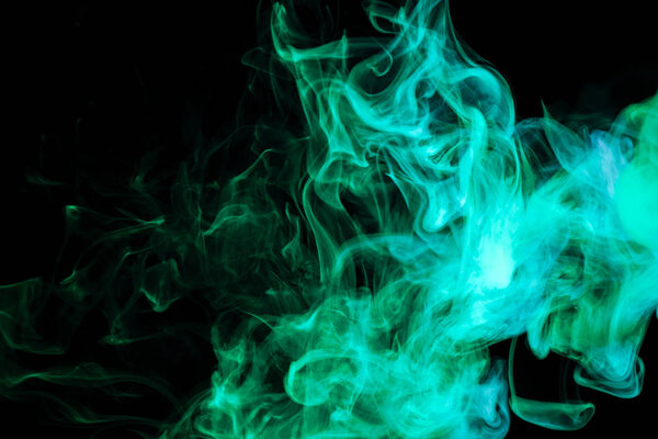 Thick green colorful smoke on a black isolated background. Background from the smoke of vape