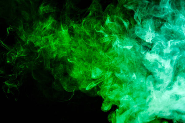 Green cloud of smoke of black isolated background. Background from the smoke of vape