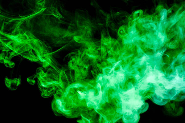 Colorful green smoke on a black isolated background. Background from the smoke of vape