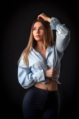 T-shirt ve jeans gülümseyen ve izole siyah arka plan üzerine poz güzel genç sarışın kadın