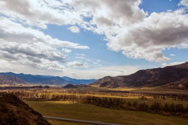 Chemal bölgesinde Altay yüksek dağların erken Bahar ile iğne yapraklı manzara ve huş ağacı orman, gökyüzünde bulutlar ile kaplıdır