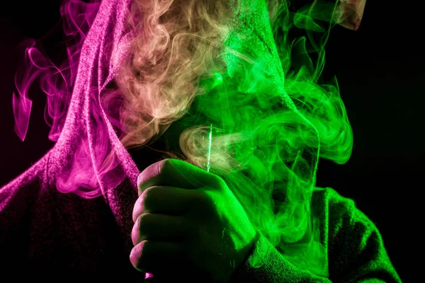 Pohledný Muž Černé Kápi Kouří Vydechuje Velké Mraky Zabarví Zeleně — Stock fotografie