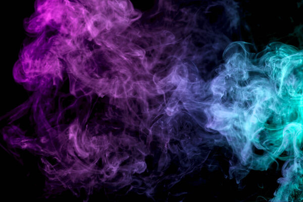 Thick colorful smoke of purple, blue and pink on a black isolated background. Background from the smoke of vape
