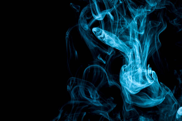 Thick blue colorful smoke on a black isolated background. Background from the smoke of vap