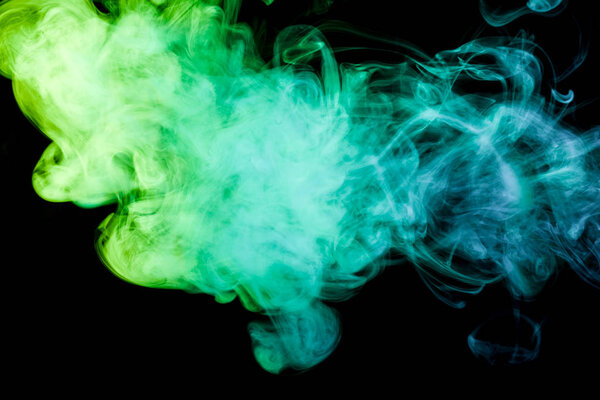 Colorful yellow and green smoke on a black isolated background. Background from the smoke of vap