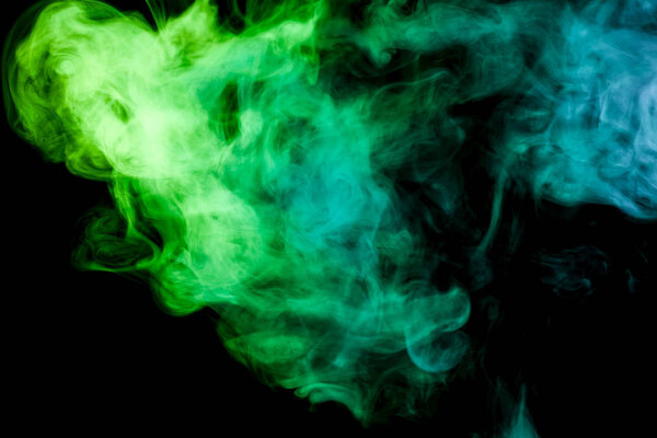 Colorful yellow and green smoke on a black isolated background. Background from the smoke of vap
