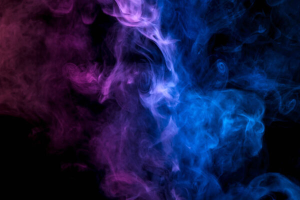 Pink and blue cloud of smoke of black isolated background. Background from the smoke of vap