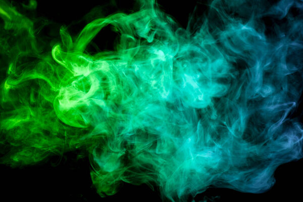 Thick blue and green colorful smoke on a black isolated background. Background from the smoke of vap