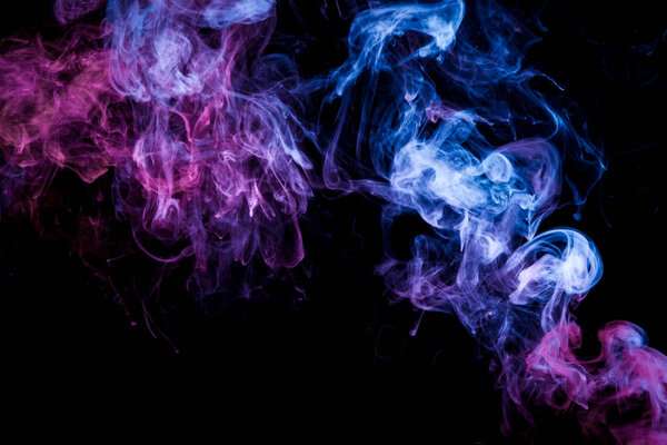 Dense multicolored smoke of blue and purple colors on a black isolated background.