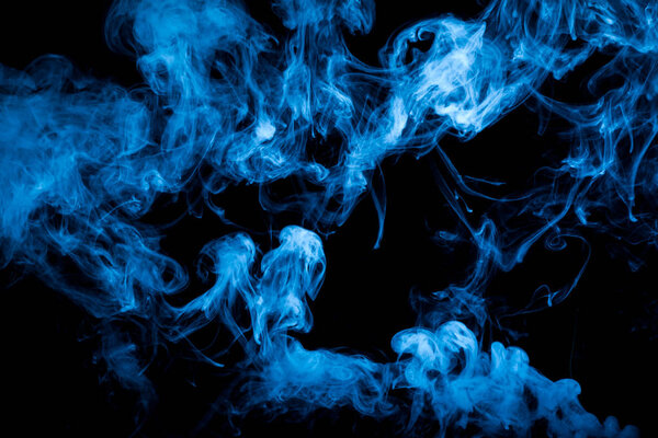 Dense blue multicolored smoke on a black isolated background.