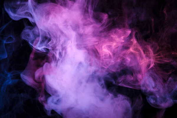 Thick colorful smoke of pink, purple blue on a black isolated background. Background from the smoke of vap