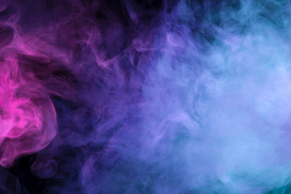 Thick colorful smoke of pink and blue on a black isolated background. Background from the smoke of vap