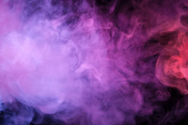 Colorful blue, pink and red smoke  on a black isolated background. Background from the smoke of vap