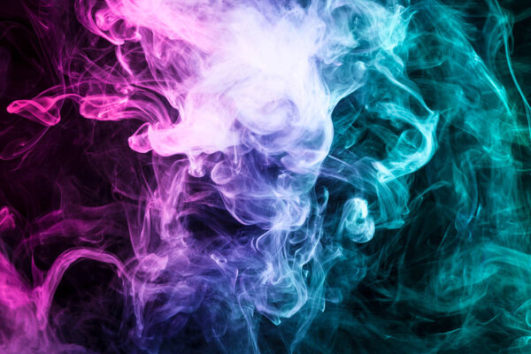 Dense multicolored smoke of pink, blue and purple colors on a black isolated background. Background of smoke vap