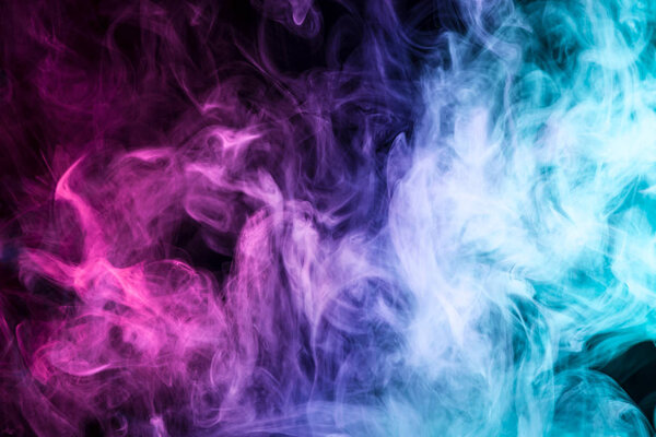 Thick colorful smoke of pink, red, blue on a black isolated background. Background from the smoke of vap