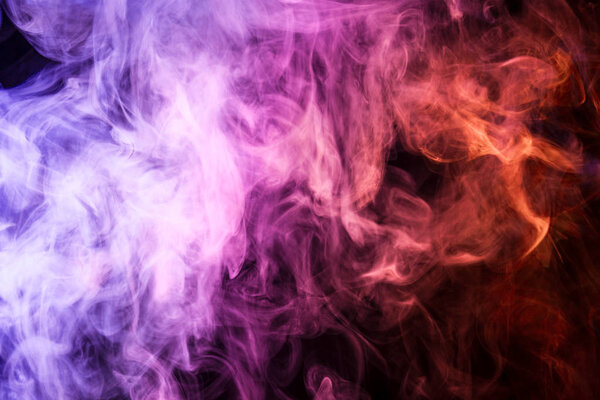 Thick colorful smoke of pink, and orange on a black isolated background. Background from the smoke of vap