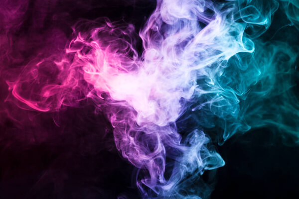 Thick colorful smoke of pink, red, blue on a black isolated background. Background from the smoke of vap