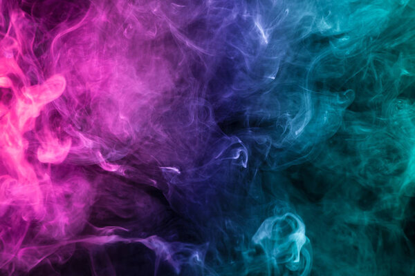 Pink, green and blue smoke on black background