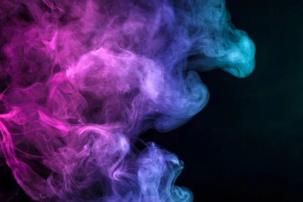 Blue and pink  cloud of smoke of  black isolated background. Background from the smoke of vap