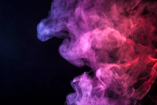 Pink, blue and red cloud of smoke of  black isolated background. Background from the smoke of vape