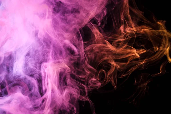 Yellow  and pink  cloud of smoke of  black isolated background. Background from the smoke of vap