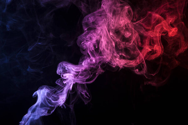 Blue, red and pink cloud of smoke of black isolated background. Background from the smoke of vap