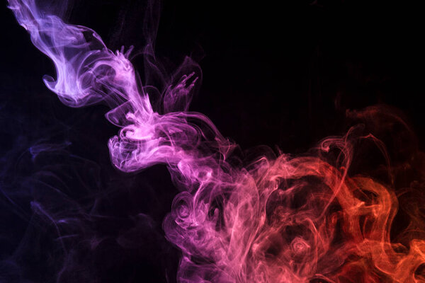 Colorful pink and orange smoke on a black isolated background. Background from the smoke of vap