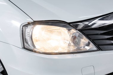 Novosibirsk, Rusya 29 Ekim 2019: Yeni beyaz Renault Logan, Led 'in farlarından birinin detaylarını kapat modern araba. 