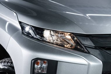 Novosibirsk, Rusya 10 Ekim 2019: Mitsubishi L200, gümüş araba farları. Dış görev ayrıntıları. Modern arabanın ön farlarından birinin detaylarını kapat. 