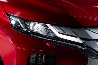 Novosibirsk, Rusya 10 Ekim 2019: Mitsubishi L200, kırmızı araba farları. Dış görev ayrıntıları. Modern arabanın ön farlarından birinin detaylarını kapat. 