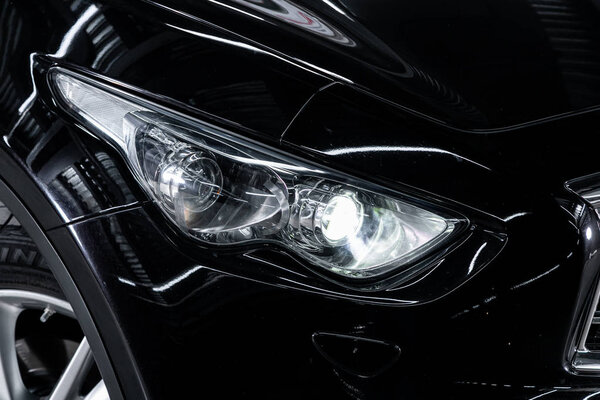 Novosibirsk, Russia  October 10, 2019:  Infiniti QX70 , white car headlights. Exterior detail. Close up detail on one of the LED headlights modern car 