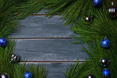 Yılbaşı ve yeni yıl için düz bir zemin. Gri ahşap masa manzaralı mavi noel topları. Noel tasarımları için hazırlan