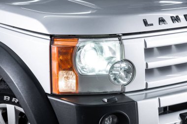 Novosibirsk, Rusya 05 Ekim 2019: Land Rover Discovery, gümüş araba farları. Dış görev ayrıntıları. Modern arabanın ön farlarından birinin detaylarını kapat. 