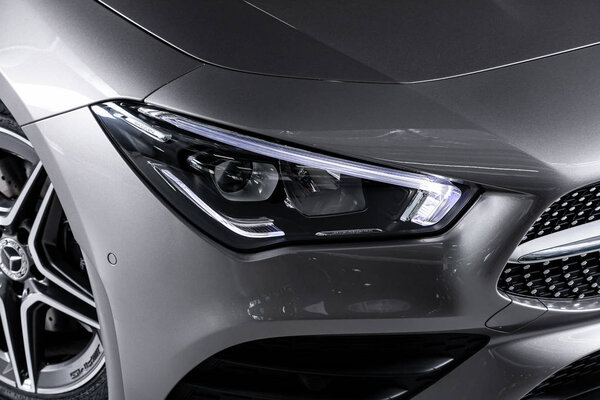 Новосибирск, Россия 10 октября 2019 года: Mercedes-Benz CLA-class, close-up of the headlight, bumper, front grille, hood, wheel. Фотография современного автомобиля на парковке в Новосибирске
 