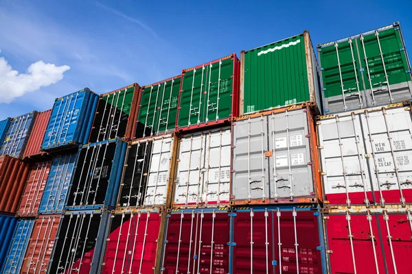 The national flag of Kuwait on a large number of metal containers for storing goods stacked in rows on top of each other. Conception of storage of goods by importers, exporters