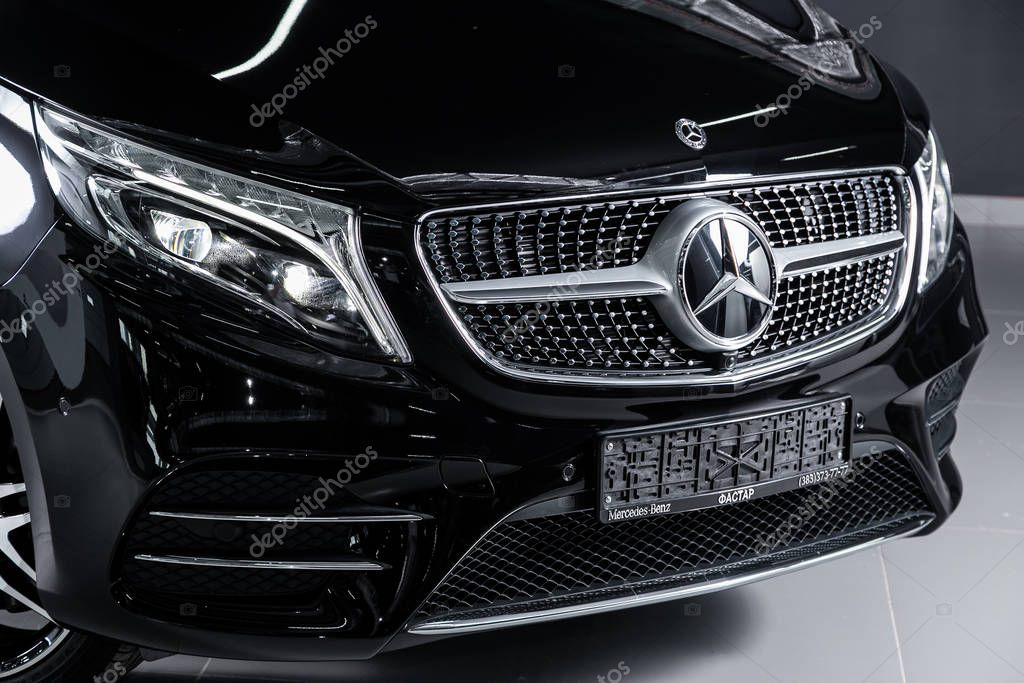 Novosibirsk, Russia  October 10, 2019:  Mercedes-Benz V-Class, close-up of the headlight, bumper, wheel, hood, grille with large Mercedes logo. Photography of a modern car on a parking in Novosibirsk