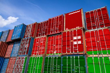 Belarus 'un ulusal bayrağı, üst üste dizilmiş malların depolanması için çok sayıda metal konteynırın üzerinde. Malların ithalatçılar ve ihracatçılar tarafından depolanması
