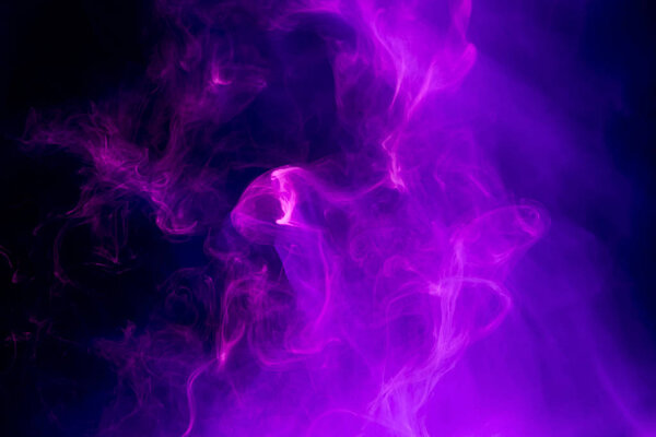 Abstract art colored purple smoke on black isolated background. Stop the movement of multicolored smoke on dark backgroun