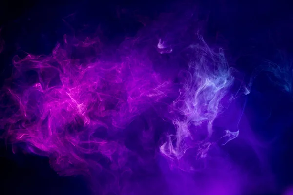 Abstract art colored purple  smoke on black isolated background. Stop the movement of multicolored smoke on dark backgroun