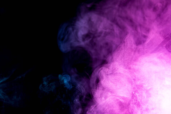 Abstract art colored purple smoke on black isolated background. Stop the movement of multicolored smoke on dark backgroun