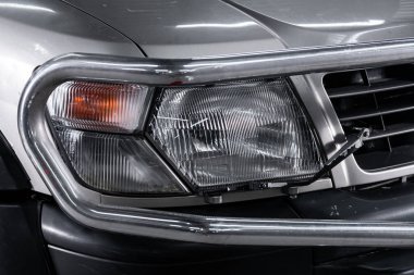 Novosibirsk, Rusya 23 Ekim 2019: Nissan Devriyesi, modern bir arabanın dışı. Modern arabanın ön farlarından birinin detaylarını kapat. 