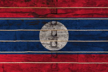 Tahta duvarda ulusal Laos bayrağı. Ulusal gurur kavramı ve ülkenin bir sembolü. Ahşap bir çitin üzerine bir iple bayraklar boyanmış.