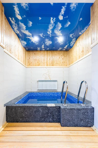 A small pool of blue mosaic with metal descent - stairs in the bathhouse of a country house