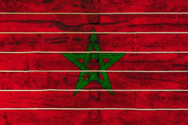 木製の壁の背景にモロッコの国旗 国家の誇りと国のシンボルの概念 ロープで木製の柵に描かれた旗 — ストック写真