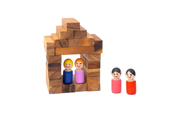 A wooden toy couple of women lives in his beautiful wooden house on a white isolated background, while other toys look after their life. Happy concept in a separate house.