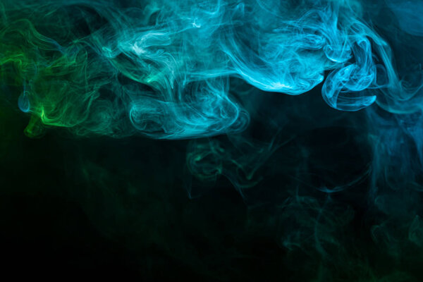 Toxic movement of color smoke abstract on black background, fire design. Fantasy green and blue smoke abstract on black background.
